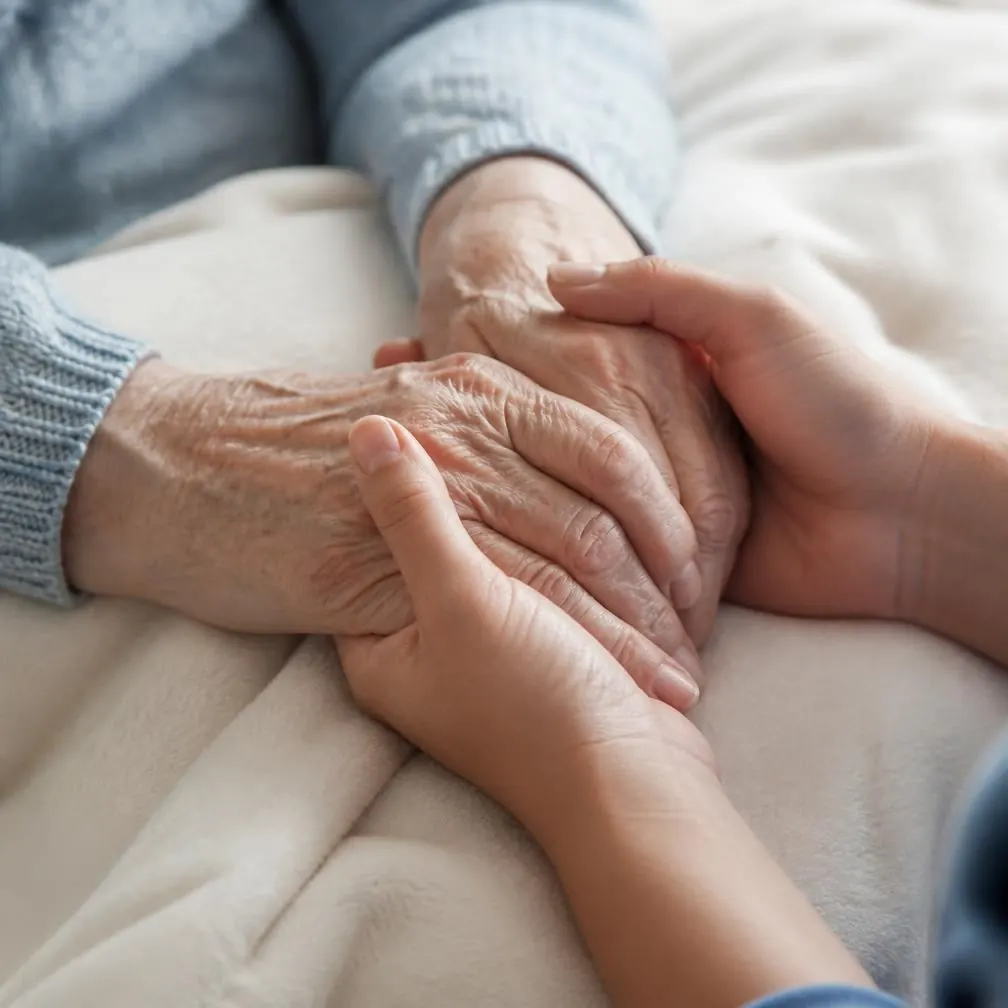 Mãos de cuidadora sobre as mãos de uma senhora idosa